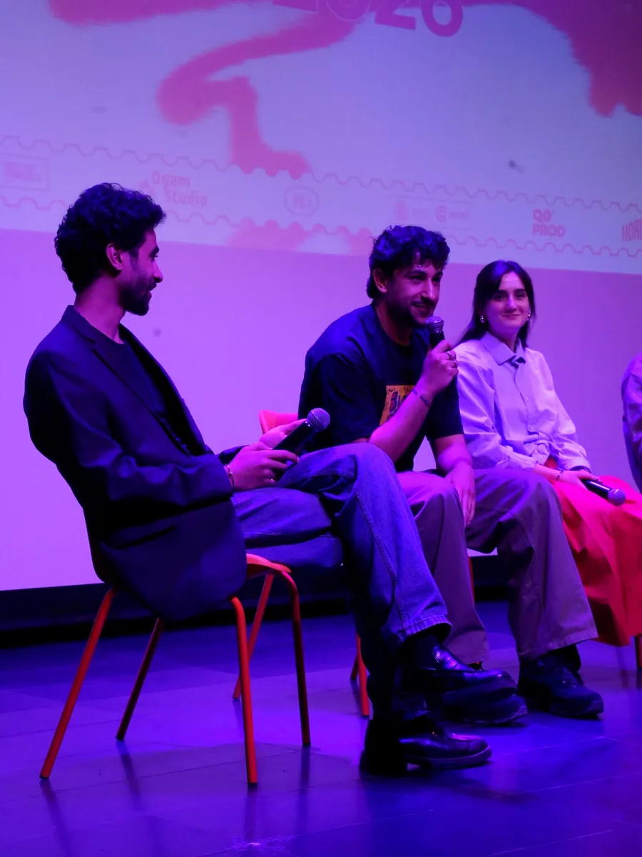 Trois intervenants assis sur scène, micro en main, lors d’une discussion.